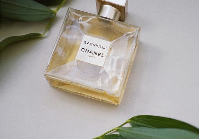 chanel perfume bottle with leaves places aside it